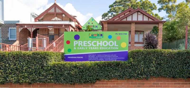 The front of Bambini of Lilyfield at 284 Balmain Road, Lilyfield: two brick houses behind a clipped hedge, with the centre's green sign on the front fence
