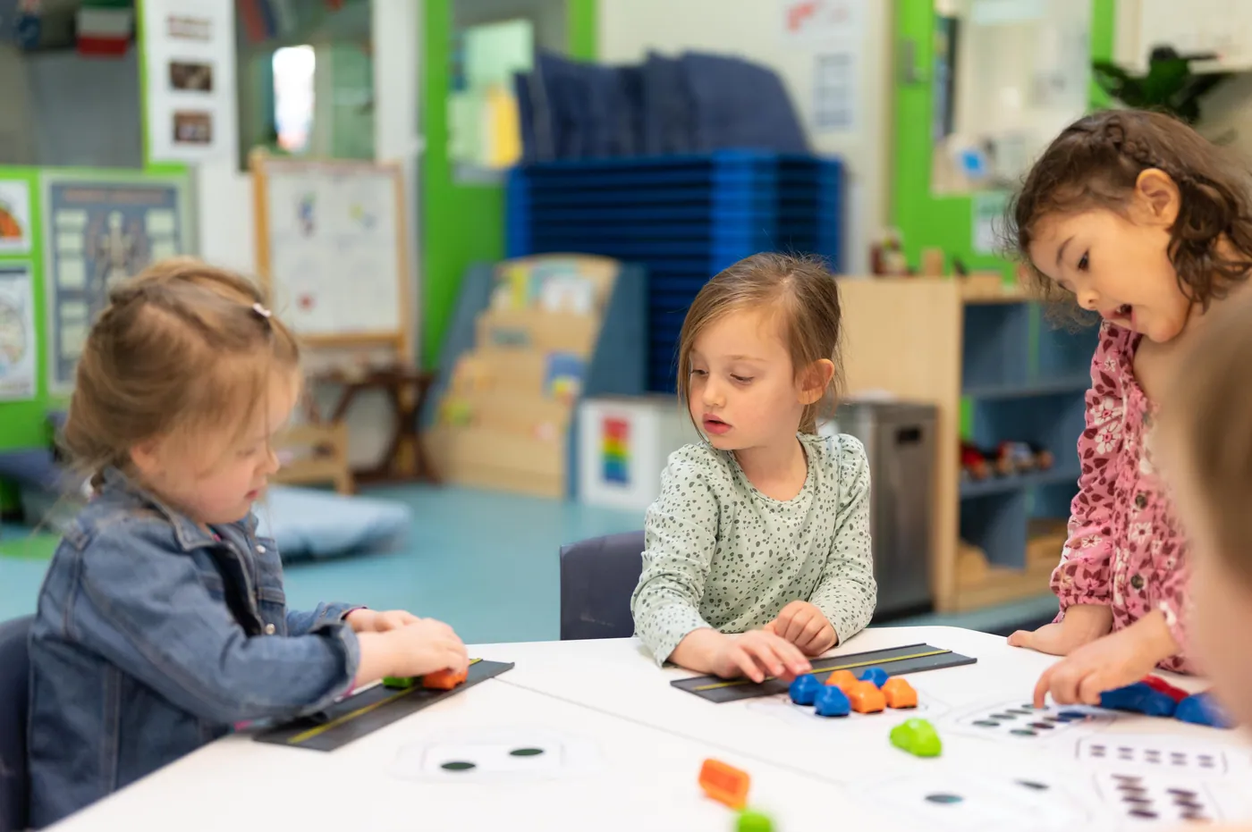 Grandi children sliding coloured blocks along number strips together