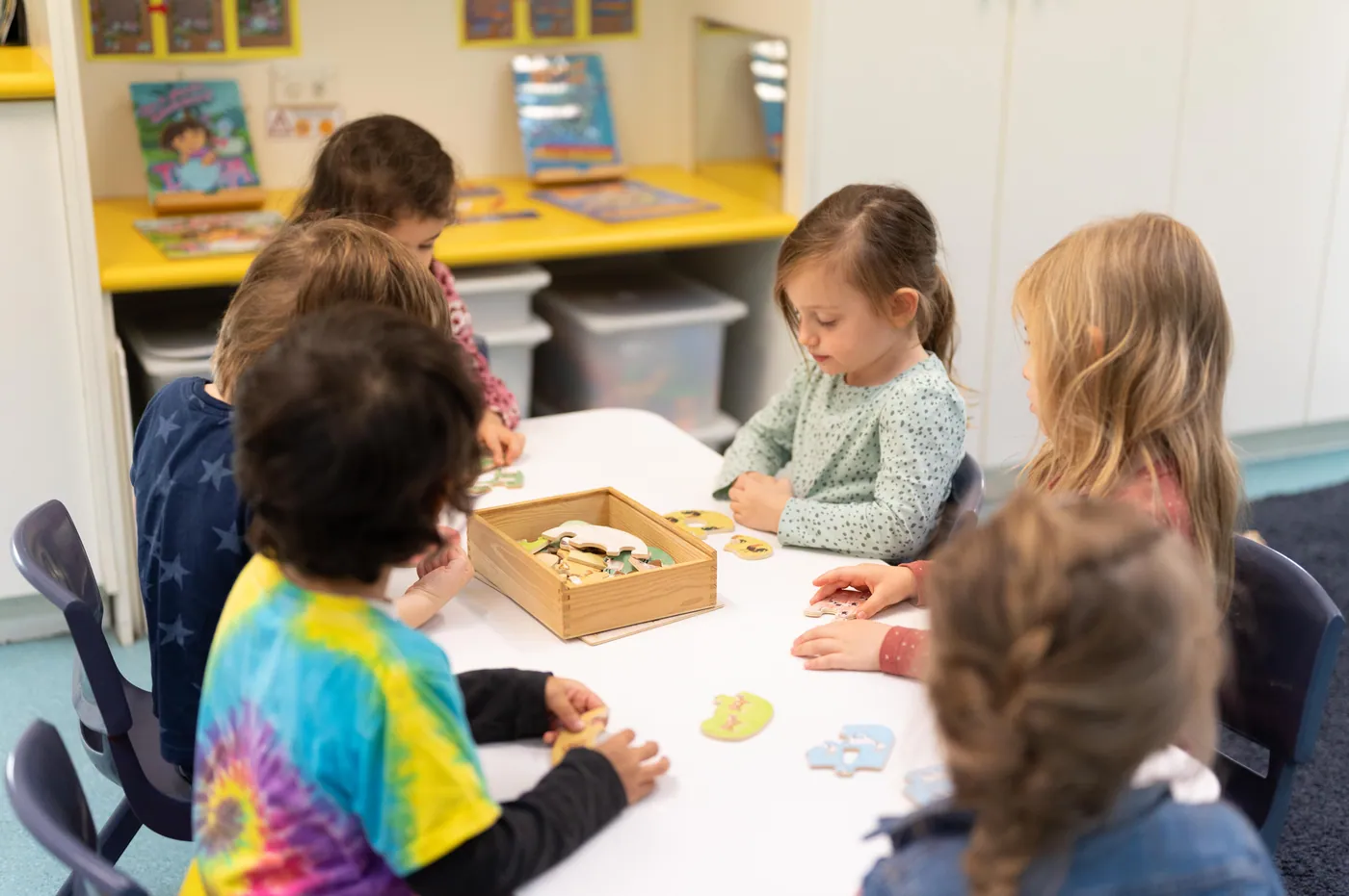Children collaborating at a table with materials