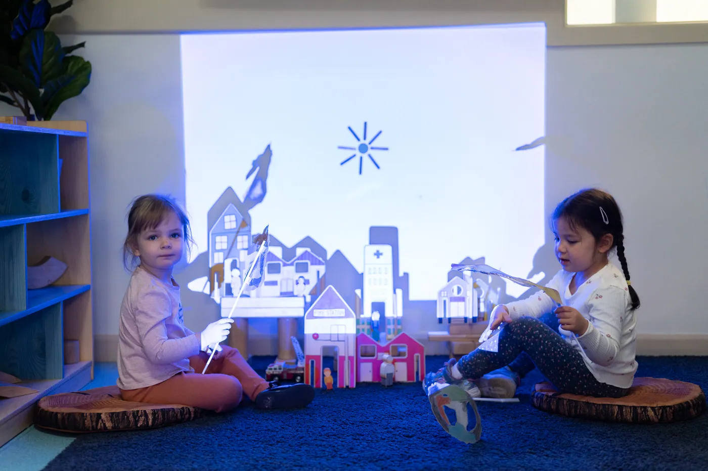 Children playing with shadows against a projector